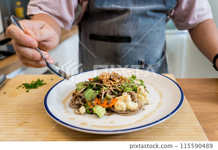 Chef at the kitchen preparing japanese buckwheat pasta with lentils 115590489