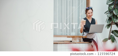 Young woman sitting outdoors with a coffee cup and laptop, embodying a relaxed yet professional lifestyle in a modern urban setting. 115590724