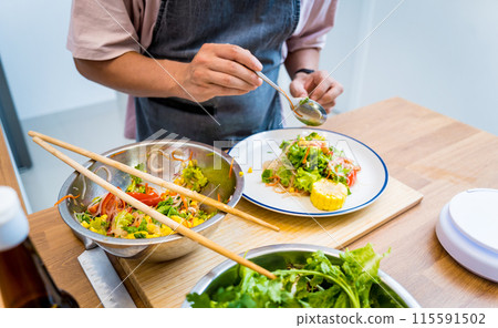 Chef at the kitchen preparing spicy glass noodle salad Chef at the kitchen preparing spicy glass noodle salad 115591502