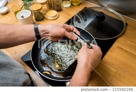 Chef at the kitchen preparing grilled eggplants with garlic Chef at the kitchen preparing grilled eggplants with garlic 115592198