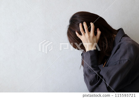 A woman holding her head worried image A woman holding her head worried image 115593721