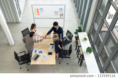 Business partners join hands in the modern office. Business executives team meeting business plan in modern office with laptop computer, tablet, mobile phone and document on table. 115594118