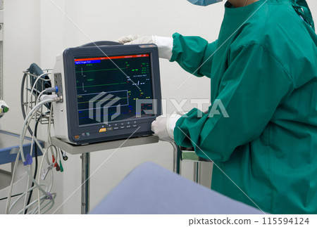 A dedicated healthcare professional in a sterile surgical gown maneuvers a high-tech machine, the latest in medical advancements, underscoring the intersection of technology and medicine. 115594124