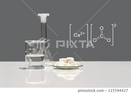 Calcium carbonate chip in chemical watch glass with molecular structure on white laboratory table. Side view Calcium carbonate chip in chemical watch glass with molecular structure on white laboratory table. Side view 115594427