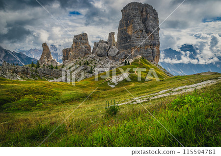 Green meadow and Cinque Torri rock formations, Dolomites 115594781