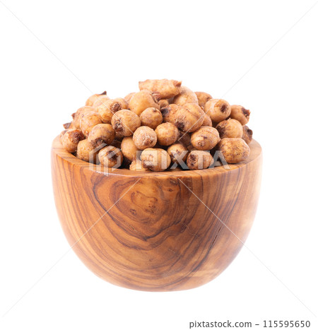 Tiger nuts in wooden bowl, isolated on white background. Pile of chufa nuts, earth almond or chufa sedge. Cyperus esculentus. Tiger nuts in wooden bowl, isolated on white background. Pile of chufa nuts, earth almond or chufa sedge. Cyperus esculentus. 115595650