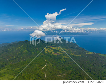 Mountain landscape with green hills and forest. Blue sky and clouds. Camiguin Island. Philippines. Mountain landscape with green hills and forest. Blue sky and clouds. Camiguin Island. Philippines. 115595820