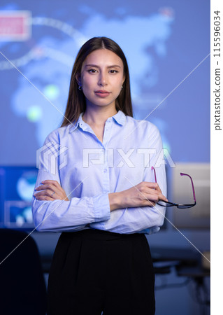 Confident female Cybersecurity Analyst or Manager in large Cyber Security Operations Center SOC handling Threats Confident female Cybersecurity Analyst or Manager in large Cyber Security Operations Center SOC handling Threats 115596034