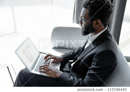 Man wearing official style suit working online on laptop in office Man wearing official style suit working online on laptop in office 115596485