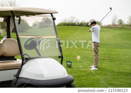 Young guy exercising in playing golf and looking concentrated 115596525
