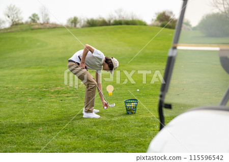 Young guy exercising in playing golf and looking concentrated 115596542