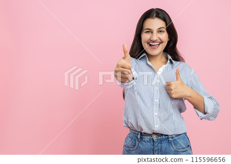 Smiling Indian woman showing thumbs up recommending advertisement Smiling Indian woman showing thumbs up recommending advertisement 115596656