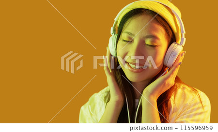 Music relaxation. Hipster woman. Color light flamboyant happy female in headphones enjoying playlist bright isolated on yellow empty space background. Music relaxation. Hipster woman. Color light flamboyant happy female in headphones enjoying playlist bright isolated on yellow empty space background. 115596959