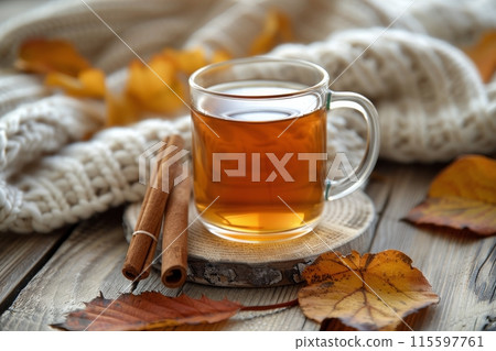 Warm Autumn Tea With Cinnamon Sticks and Knitted Blanket 115597761