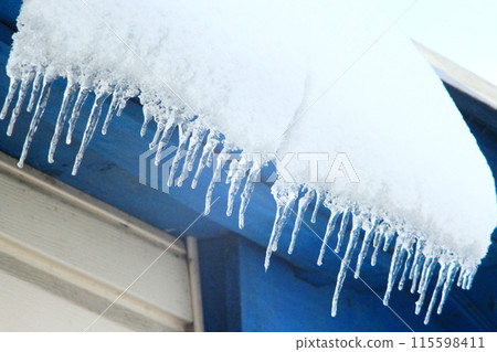 Icicles hang down from under the roof of the house.Winter scenery Icicles hang down from under the roof of the house.Winter scenery 115598411