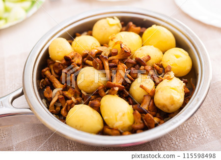 Delicious fried chanterelles with new potatoes in a frying pan Delicious fried chanterelles with new potatoes in a frying pan 115598498
