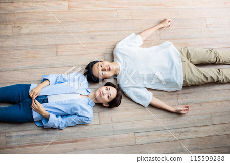 A friendly couple lying on the floor A friendly couple lying on the floor 115599288