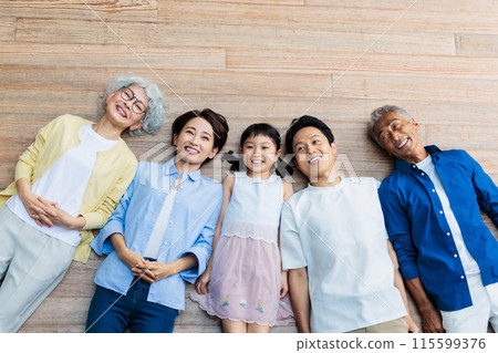 A friendly three-generation family lying on the floor 115599376