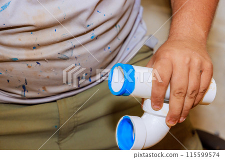 Using glue to join plastic PVC pipes by plumber Using glue to join plastic PVC pipes by plumber 115599574
