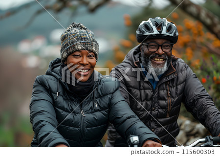 Happy old couple cycling mountain bikes in forest 115600303
