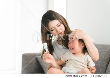Young Asian mother/mom taking child's temperature (fever, fever, cold, crying) 115602385