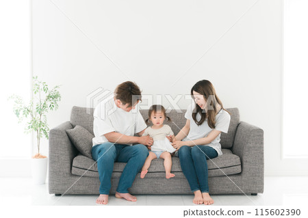 Young Japanese family sitting on the sofa at home 115602390