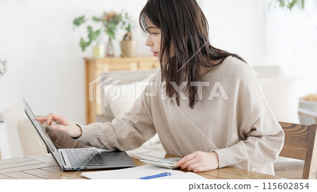 一名婦女在網路上研究和計算成本 一名婦女在網路上研究和計算成本 115602854