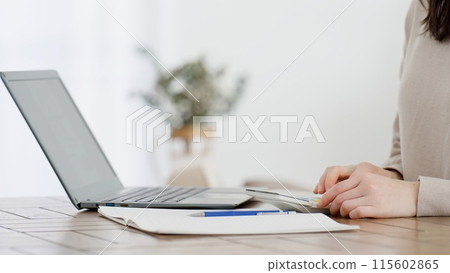 A woman calculating expenses with a calculator A woman calculating expenses with a calculator 115602865