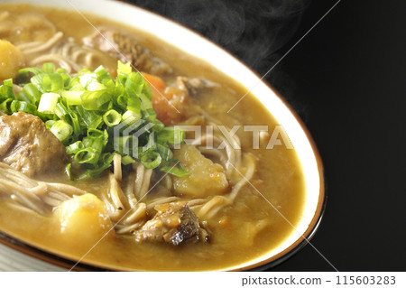 Hot curry soba noodles with plenty of green onions photographed against a black background Hot curry soba noodles with plenty of green onions photographed against a black background 115603283
