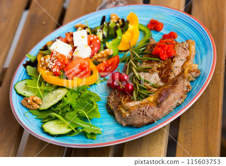 Fried beef loin with salad on wooden background 115603753