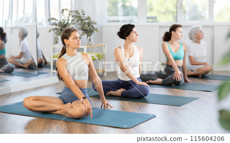 Young woman doing yoga in group in studio Young woman doing yoga in group in studio 115604206