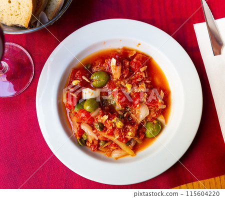 Murcian salad from canned tomatoes, tuna, onion, egg and olives 115604220