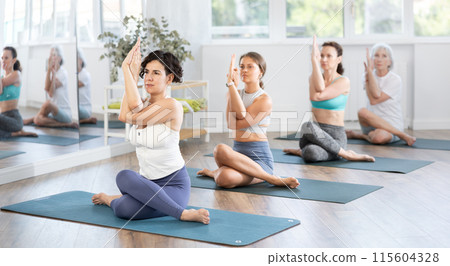 Group of women of different ages working out practice Lord of fishes pose 115604328