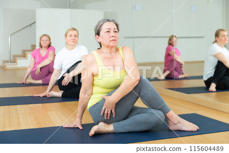 Active elderly woman practicing yoga at group 115604489