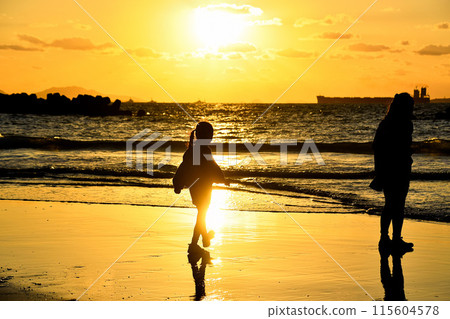 日落時孩子們在海灘上玩耍 115604578