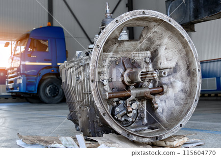 A disassembled industrial truck transmission awaiting repair or recycling, placed on a wooden pallet A disassembled industrial truck transmission awaiting repair or recycling, placed on a wooden pallet 115604770