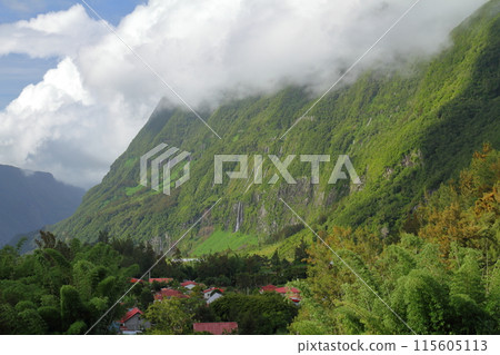 A view of the waterfall flowing down the cliffs from the village of Hell-Bourg in the Salazie Valley, a World Heritage Site on the French overseas territory of Reunion Island 115605113