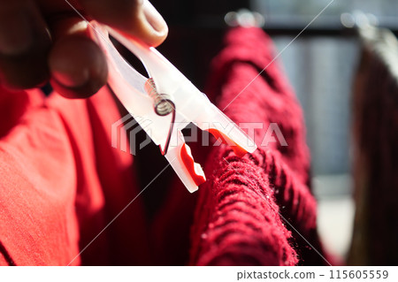 putting a blue clothespins on cloth putting a blue clothespins on cloth 115605559