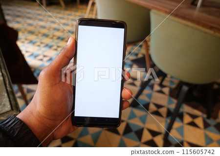 young man hand using smart phone with white screen at cafe young man hand using smart phone with white screen at cafe 115605742