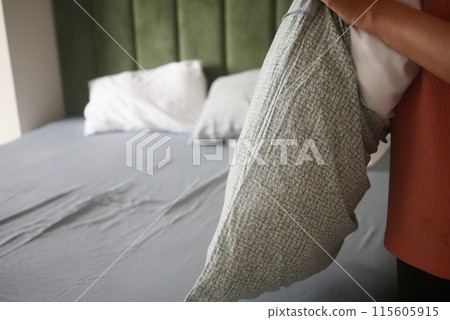 Woman Puts Pillow Into Pillowcase. Woman Puts Pillow Into Pillowcase. 115605915