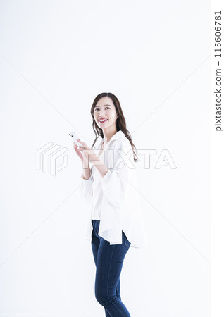 A young woman operating a smartphone 115606781