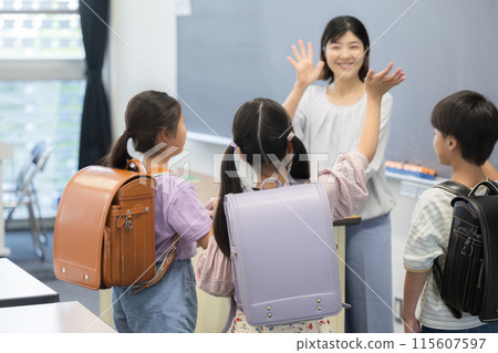 Teacher and students saying goodbye in an elementary school classroom Teacher and students saying goodbye in an elementary school classroom 115607597