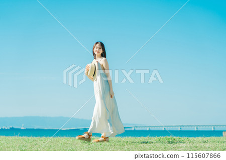 A woman in a dress enjoying vacation at a resort 115607866