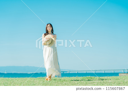 A woman in a dress enjoying vacation at a resort A woman in a dress enjoying vacation at a resort 115607867