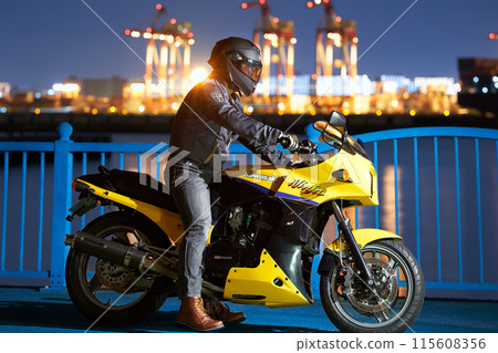 晚上，一名男子在港口騎摩托車 115608356