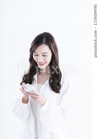 A young woman operating a smartphone 115609490
