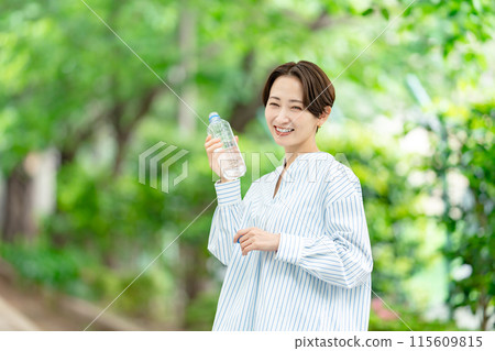 Woman drinking water, fresh greenery 115609815