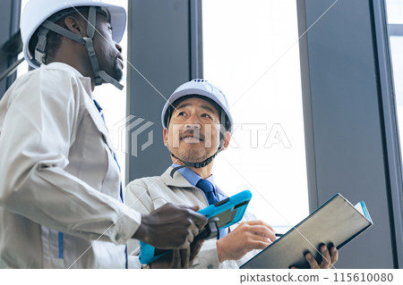 Group of multinational engineers having a conversation in a building 115610080