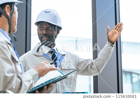 Group of multinational engineers having a conversation in a building Group of multinational engineers having a conversation in a building 115610081