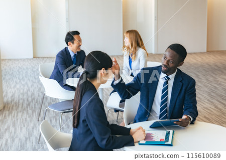 Group of multinational business people having a conversation in a lobby 115610089